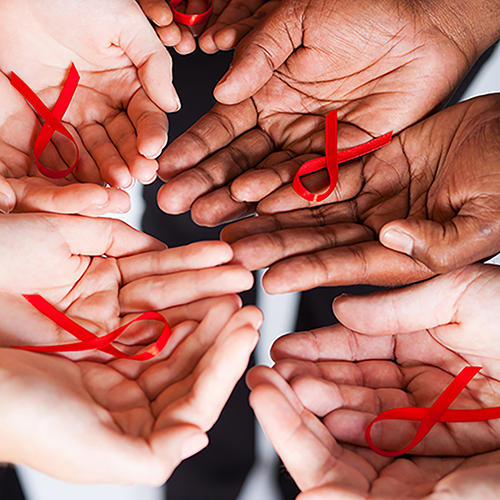Mixed race group holding red ribbon for AIDS Awareness